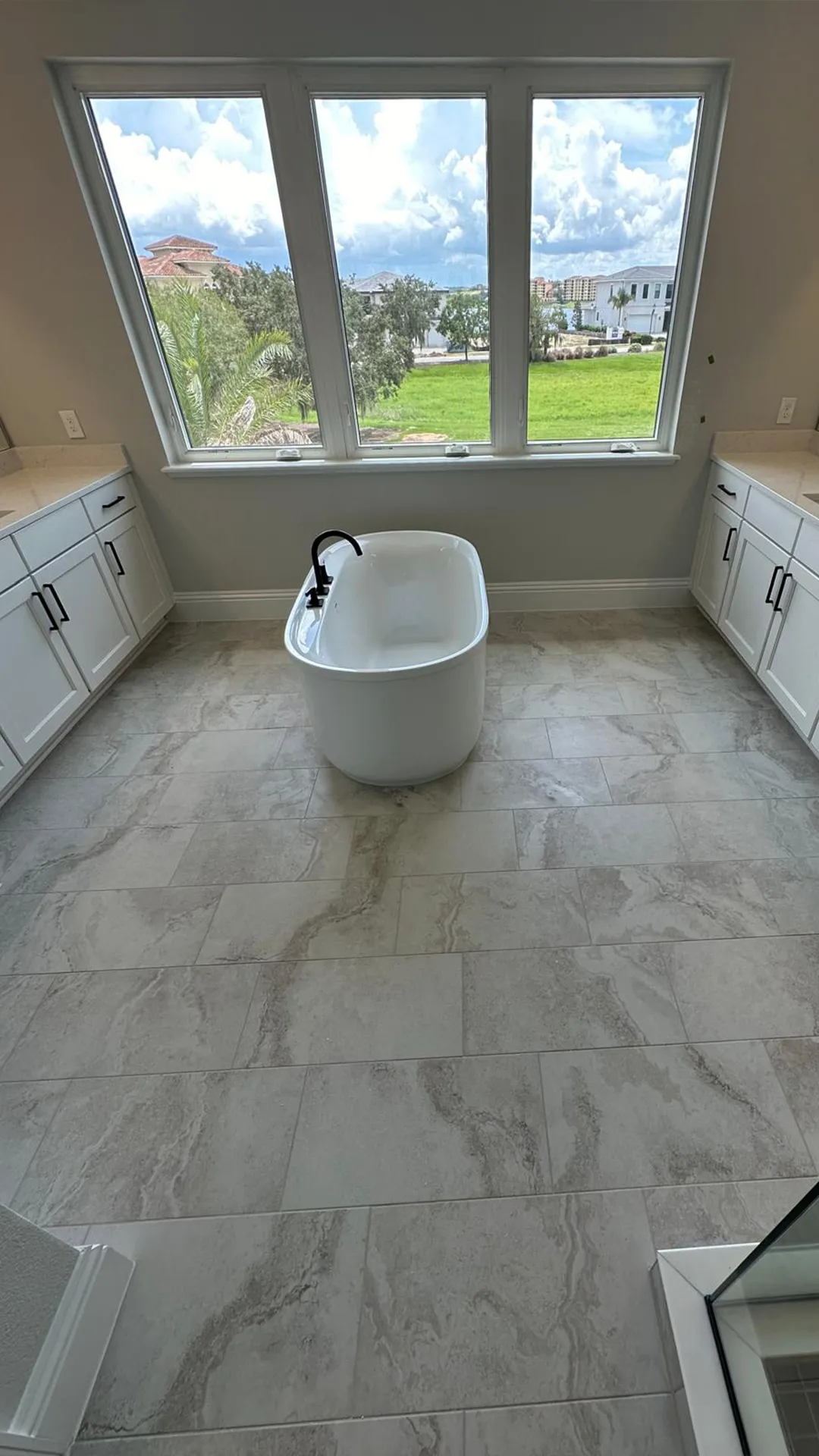 Modern bathroom with wall tile, double sink vanity and freestanding bathtub